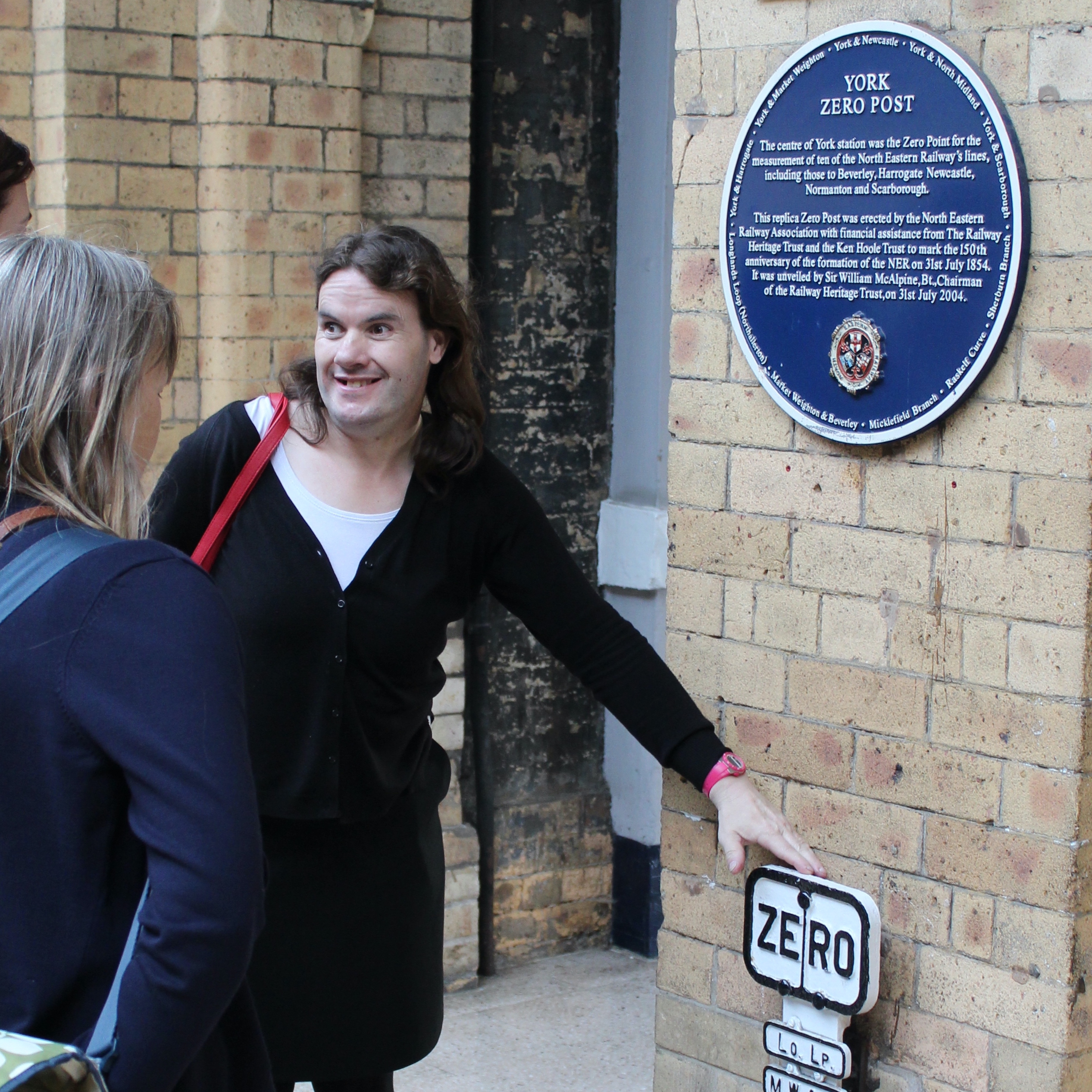 Gemma pointing at a blue plaque