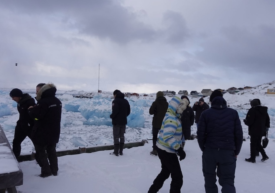 Participants standing against an ice filled hardbour background